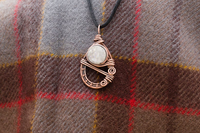 Teardrop shaped wire wrapped pendant with a white, sparkling druzy stone in the center
