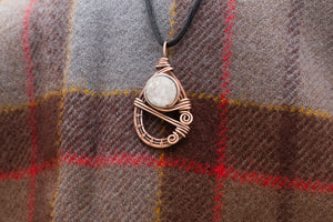Teardrop shaped wire wrapped pendant with a white, sparkling druzy stone in the center